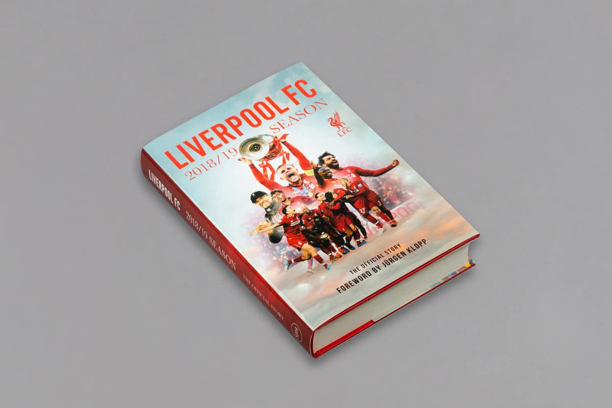 A captivating book titled "Liverpool FC 2018/19 Season" features vibrant images of players celebrating triumphantly on the cover, resting elegantly on a gray surface.