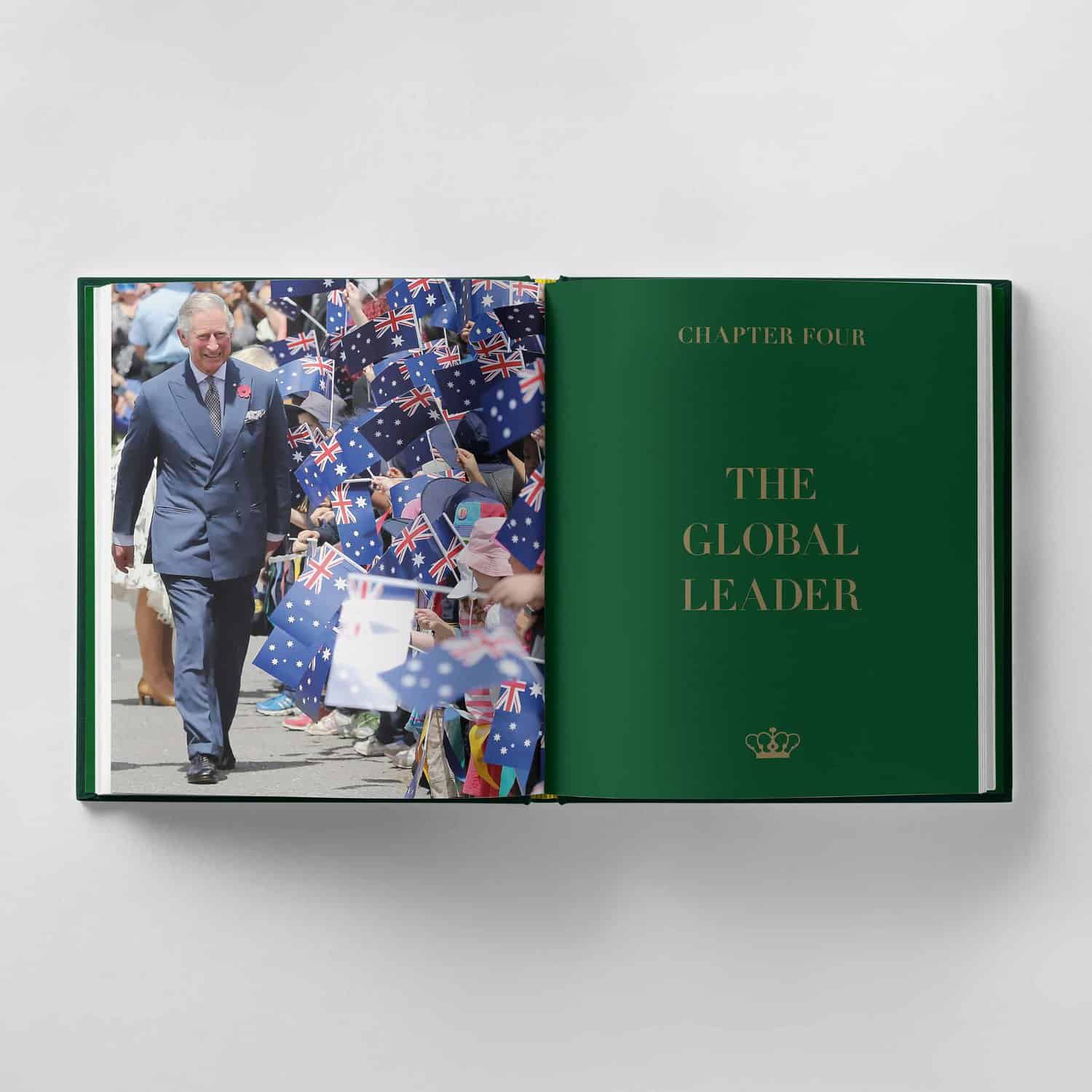Open book showing a photograph of King Charles III walking past people waving flags on the left page, and the right page titled "Chapter Four: The Global Leader" with a crown symbol.
