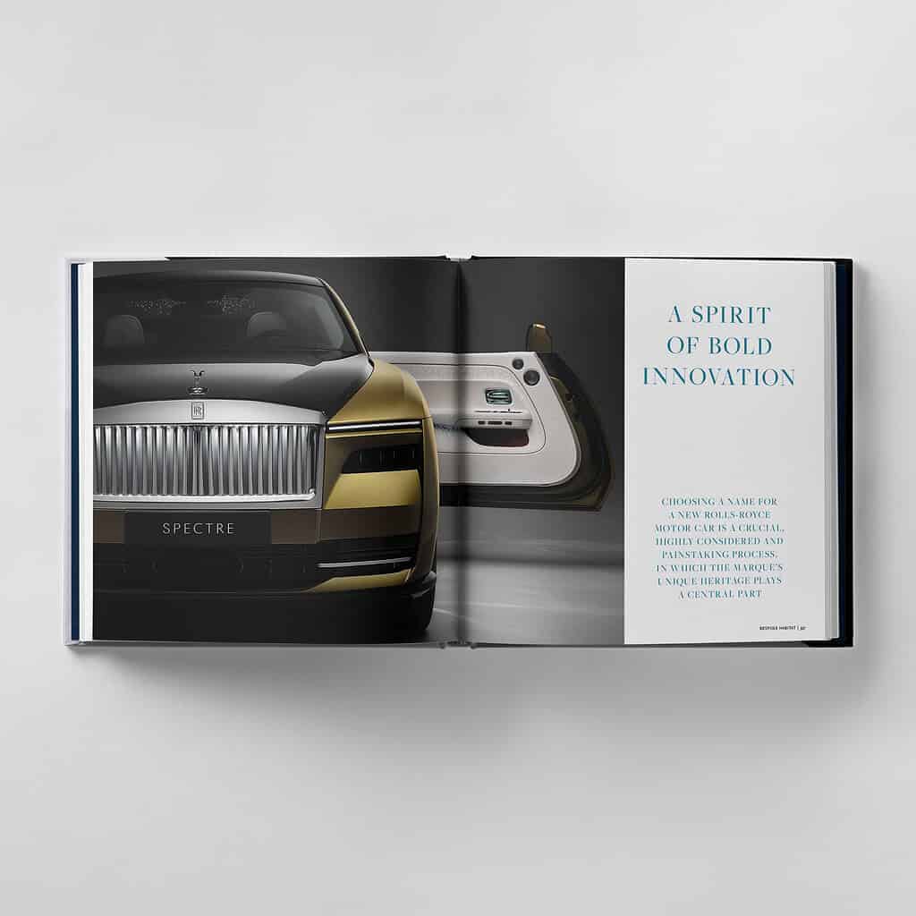 Open book displaying a luxury car advertisement featuring a front view of a vehicle and an interior dashboard, with the text "A Spirit of Bold Innovation" reflecting the brand's strive for perfection on the right page.