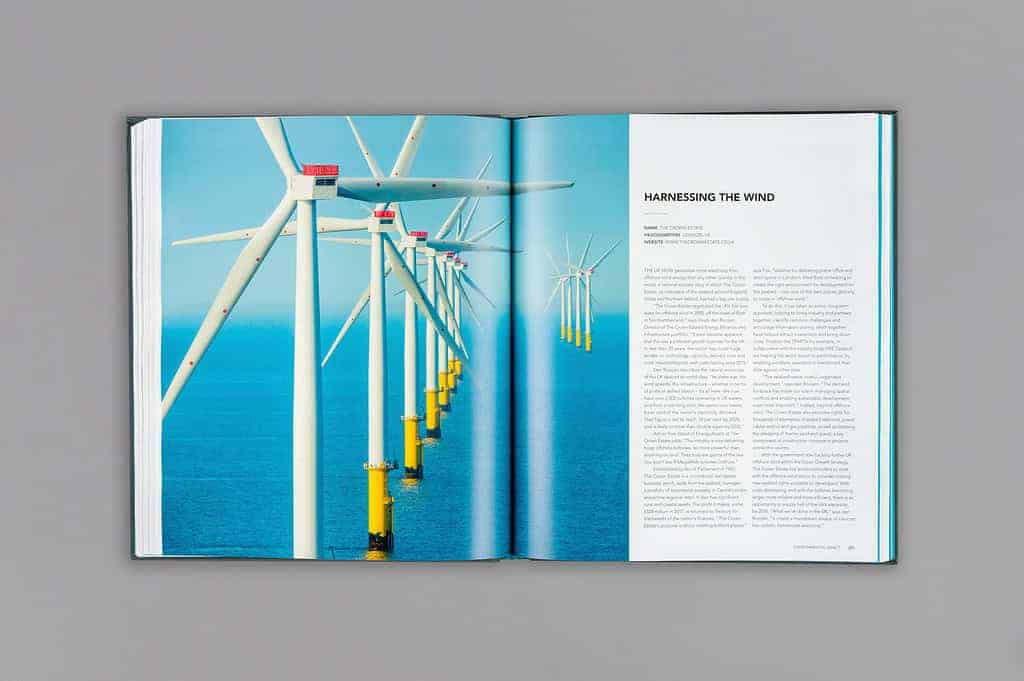 An open book reveals a stunning photo of offshore wind turbines spanning the ocean on the left page and text titled "Harnessing the Wind" on the right. These pages illustrate how such innovations are shaping a sustainable world for future generations.