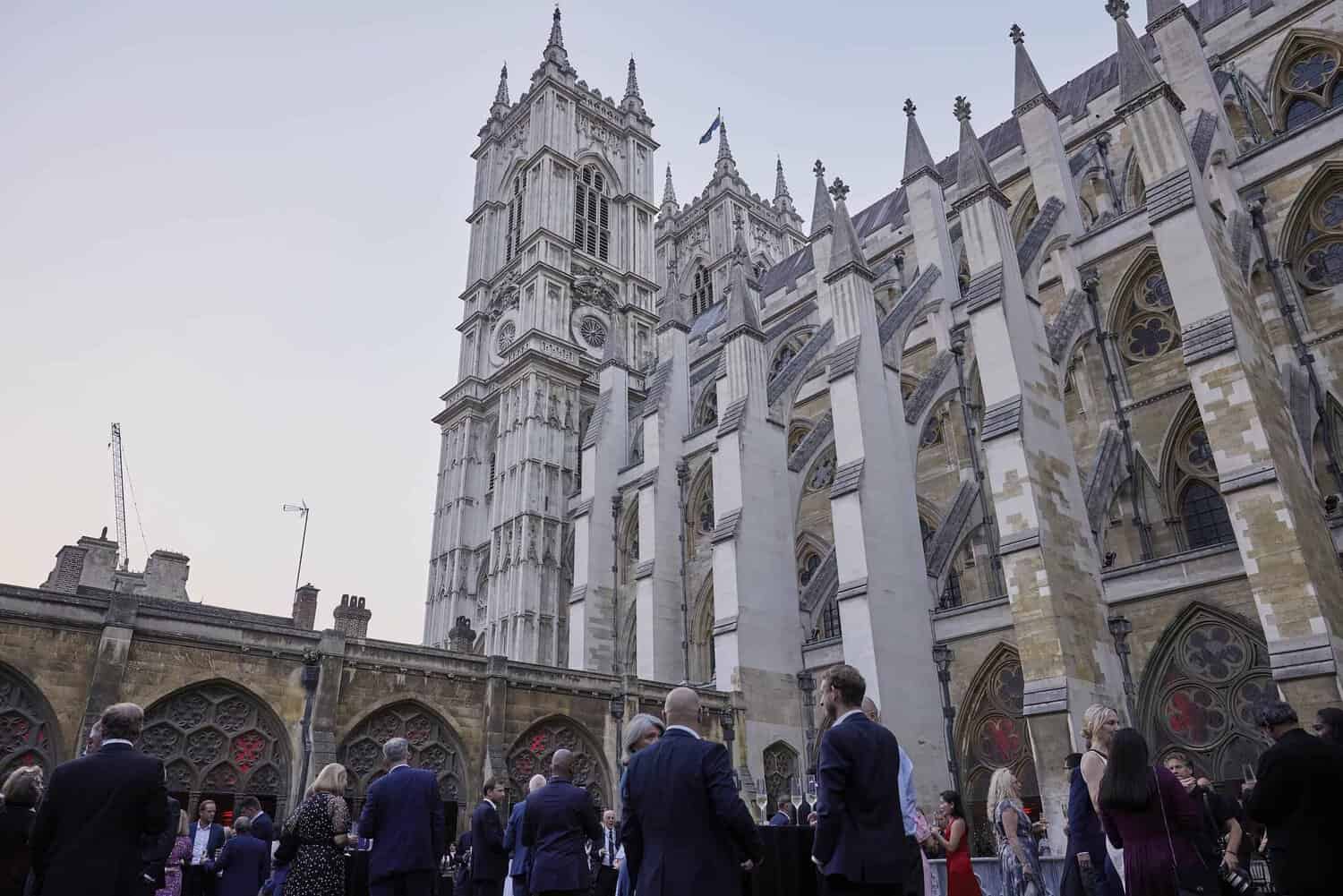 People gathered outside a large, historic cathedral with intricate architecture and tall towers, celebrating 75 years of the NHS.