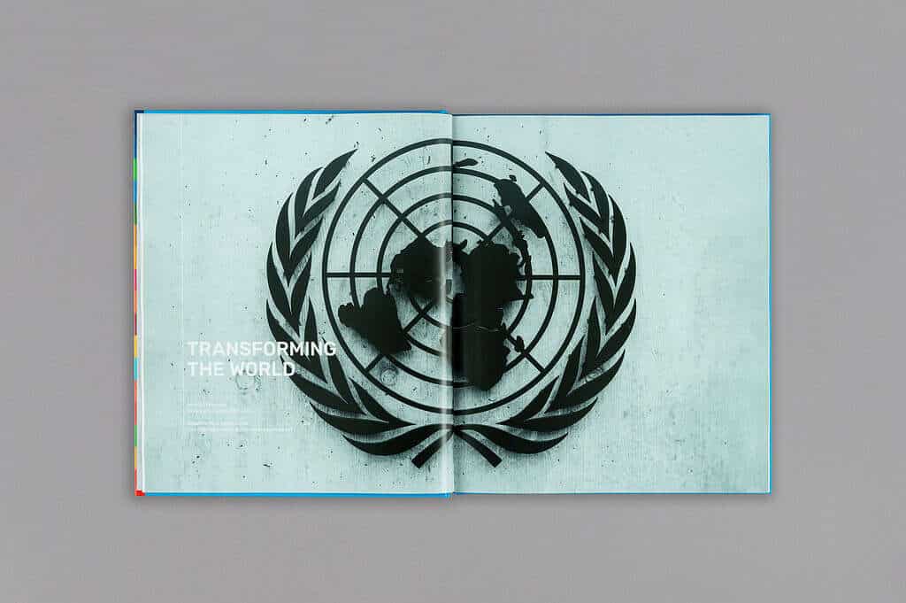 Open book with a design featuring the United Nations emblem and the text "Transforming the World" on a gray background, commemorating UN75 and promoting sustainable engineering initiatives.