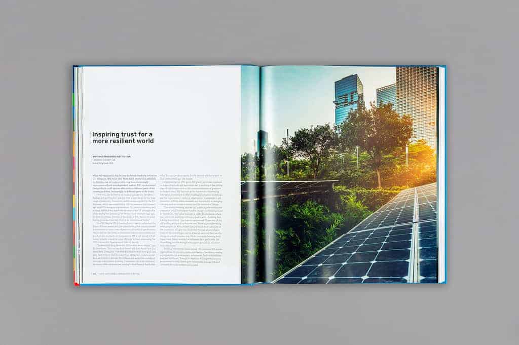 Open magazine featuring the article "Inspiring trust for a more resilient world" on the left, while on the right, an image of sustainable engineering unfolds with a solar panel walkway surrounded by city buildings and lush greenery.