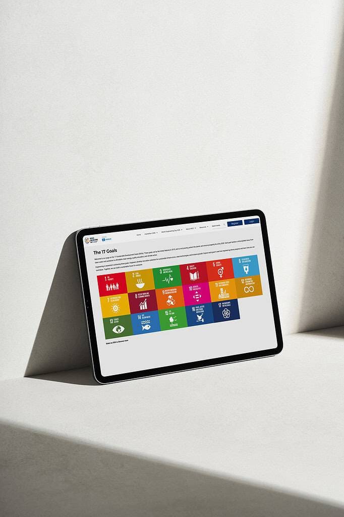 A tablet showcasing the United Nations 17 Sustainable Development Goals on a website lies elegantly on a light-colored surface, perfectly capturing the spirit of World Engineering Day.